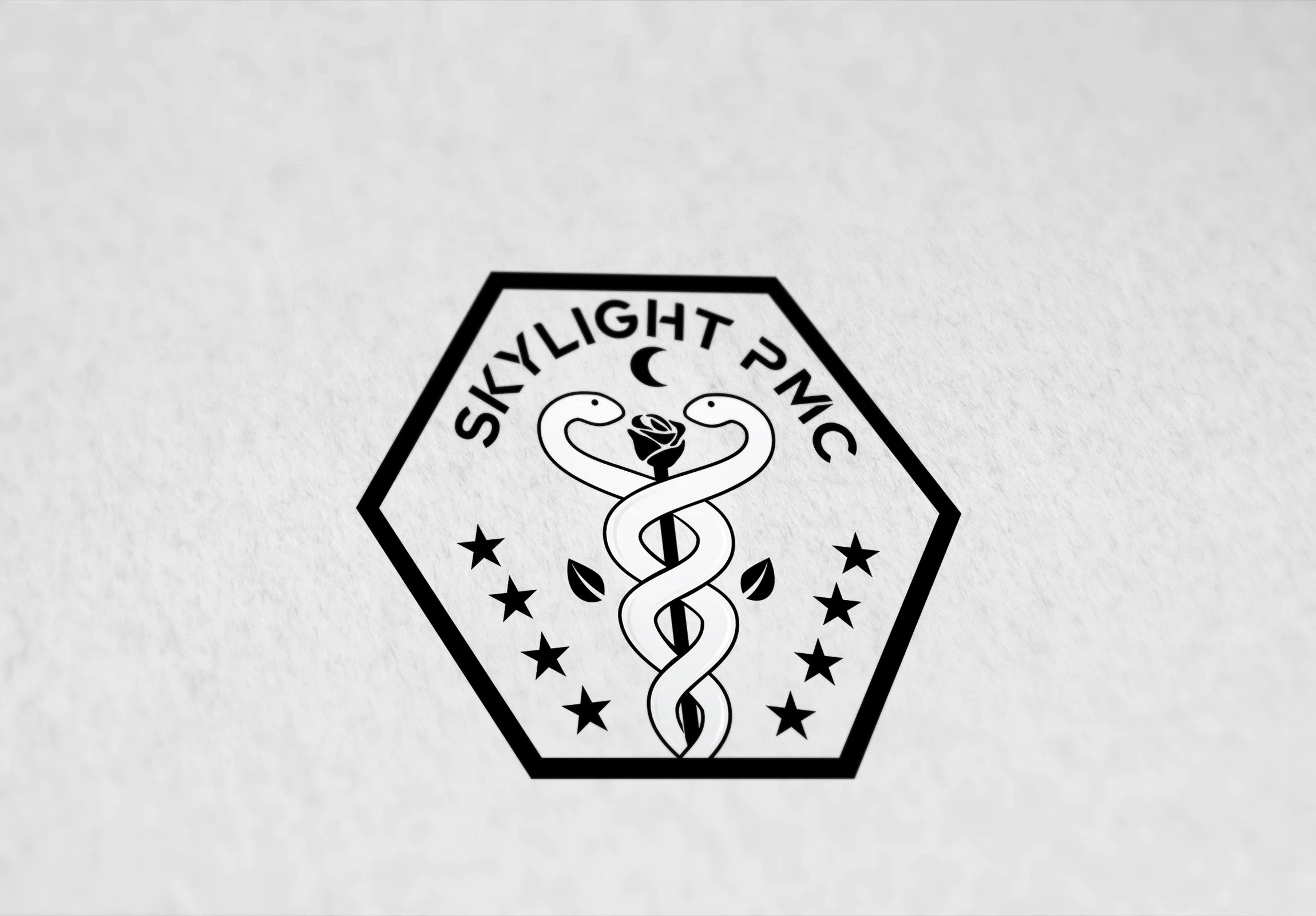 Black and white emblem with the text 'SkyLight PMC' around a central caduceus symbol, a crescent moon at the top, a rose in the middle, surrounded by stars.